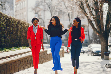Elegant black women standing in a summer park. Businesswomen in a elegant clothes