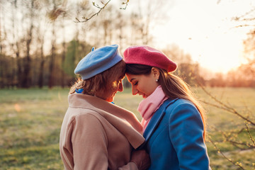 Senior mother and her adult daughter hugging in spring forest. Mother's day concept. Family values