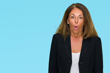 Beautiful middle age business adult woman over isolated background afraid and shocked with surprise expression, fear and excited face.
