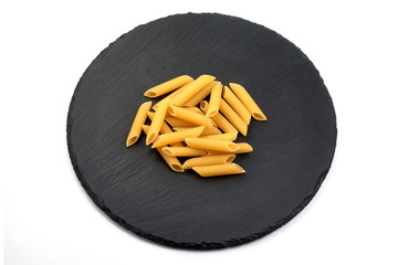 Penne pasta on a slate shale plate, Itallian food, close-up, isolated on white background