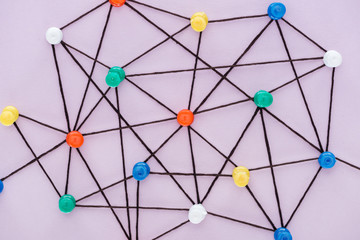 top view of push pins connected with strings Isolated On pink, network concept