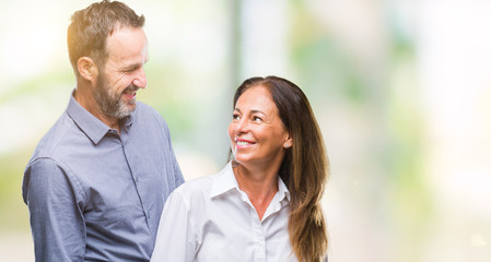 Obraz premium Middle age hispanic business couple over isolated background with serious expression on face. Simple and natural looking at the camera.
