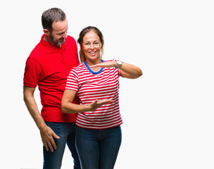 Fototapeta premium Middle age hispanic couple in love over isolated background gesturing with hands showing big and large size sign, measure symbol. Smiling looking at the camera. Measuring concept.