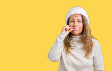 Beautiful middle age woman wearing winter sweater and hat over isolated background mouth and lips...
