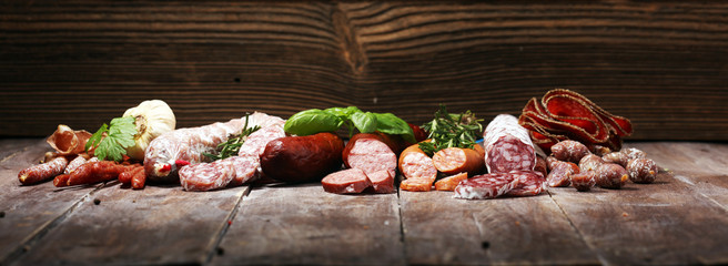 cold meat assortment with delicious salami and  fresh herbs . Variety of meat products including coppa and sausages © beats_