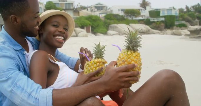Side view of African american couple interacting with each other on the beach 4k