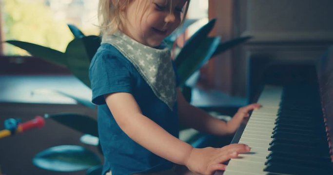 Little toddler playing the piano at home