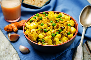 cauliflower green peas turmeric rice on a wood background