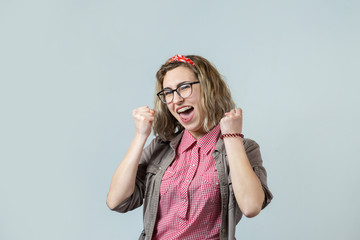 Emotional portrait of a fair-haired girl on a gray background, stormy emotions, business concept.