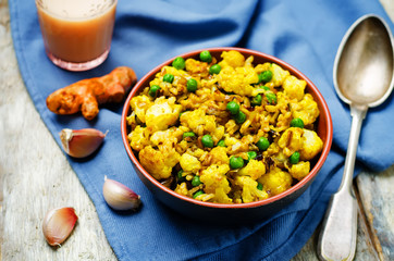 cauliflower green peas turmeric rice on a wood background