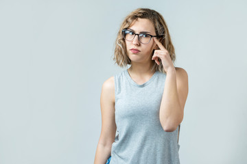 Fototapeta premium Emotional portrait of a fair-haired girl on a gray background, stormy emotions, business concept.