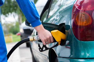 Man filling gasoline fuel in car holding nozzle