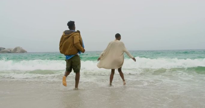 African american couple having fun together on the beach 4k