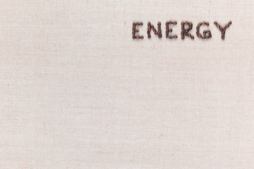 Energy word made from coffee beans on linen texture aligned top right.