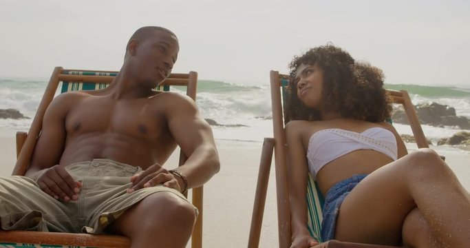 Front view of African american couple interacting with each other on the beach 4k