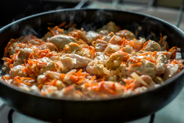 Cooking, sliced carrots and meat fried in a pan
