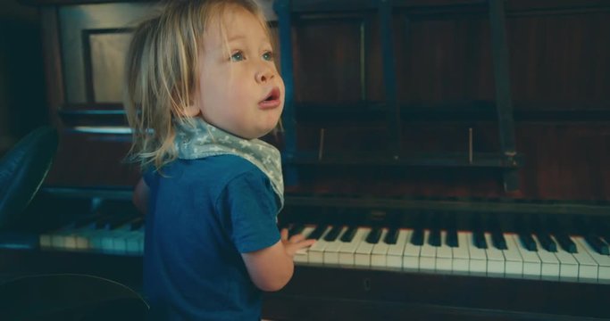Little toddler singing and playing the piano