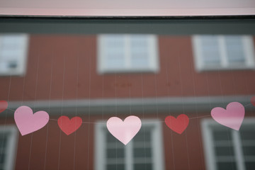 Heart Garland hanging in Store Window, Reflection of Facade