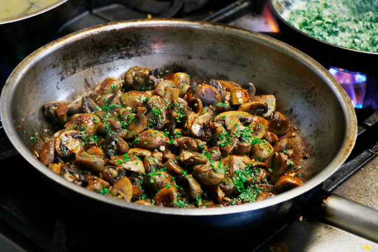 saute mushrooms in a cooking pan