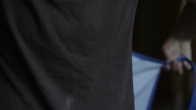 Artist preparing for making sculpture, art. Artisan puting on apron in workshop