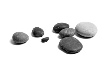 Fototapeta na wymiar Scattered sea pebbles. Heap of smooth gray and black stones isolated on white background