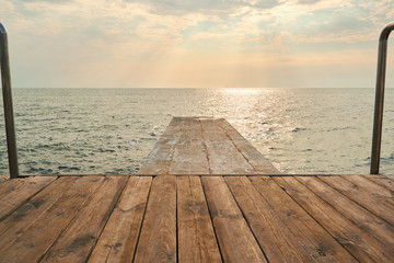 Wooden table on sunny day near sea. Sunset