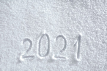 Numbers, calendar date, inscription 2021 on natural snowy surface in wintertime. Text, Winter New Year holiday background, top view