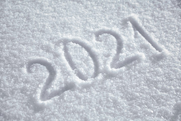 Numbers, calendar date, inscription 2021 on natural snowy surface in wintertime. Text, Winter New Year holiday background