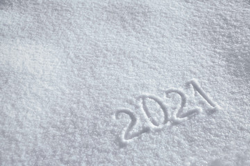 Numbers, calendar date, inscription 2021 on natural snowy surface in wintertime. Text, Winter New Year holiday background with copy space
