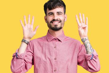 Young handsome man wearing pink shirt over isolated background showing and pointing up with fingers...