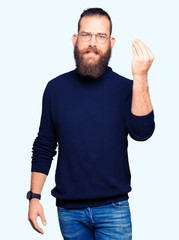 Naklejka premium Young blond man wearing glasses and turtleneck sweater Doing Italian gesture with hand and fingers confident expression