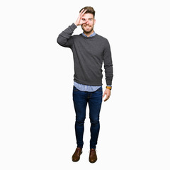 Fototapeta premium Young handsome elegant man doing ok gesture with hand smiling, eye looking through fingers with happy face.