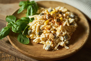 Salad of grated cheese with capers and corn  with basil on wooden table
