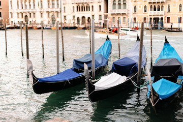 Fototapeta na wymiar gondolas with rain covers sit in the canal in venice italy