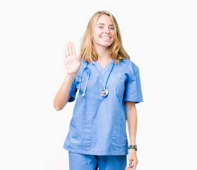 Beautiful young doctor woman wearing medical uniform over isolated background Waiving saying hello happy and smiling, friendly welcome gesture