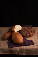 Different bread and wheat on the rustic table. Selective focus, close up