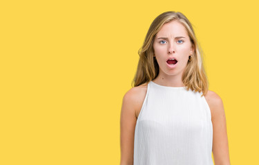 Beautiful young elegant woman over isolated background In shock face, looking skeptical and sarcastic, surprised with open mouth