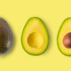Isolated avocado on a yellow background, trimmed. avocado fruit and two halves in a row, isolated on yellow background, nutrition concept