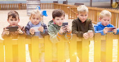 Five kidsare chatting on their smartphone