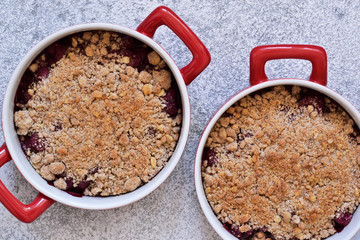 Berry crumble with nuts and ice cream on the kitchen table.