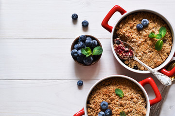 Crumble with blueberries on a white kitchen table. View from above.
