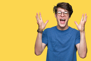 Young handsome man wearing glasses over isolated background celebrating crazy and amazed for...