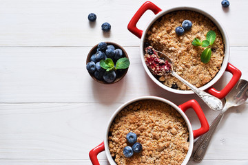 Crumble with blueberries on a white kitchen table. View from above.