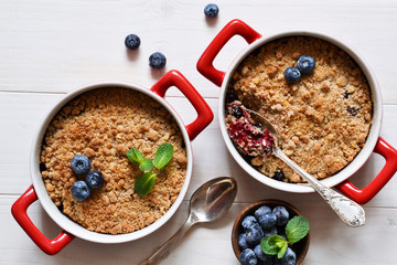 Crumble with blueberries on a white kitchen table. View from above.