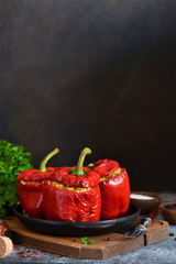 Red pepper stuffed with meat, bulgur and vegetables in a cast-iron pan. Baked stuffed peppers.