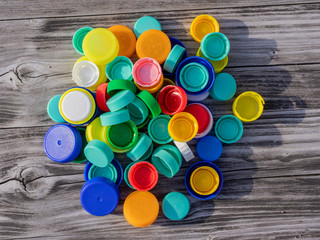 Image of colorful plastic caps on a wooden table