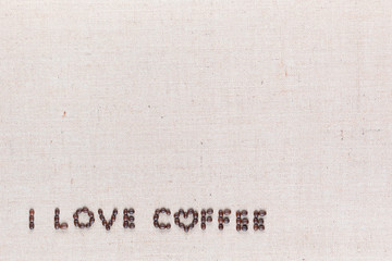 I love coffee sign from coffee beans on linen canvas, arranged bottom left.