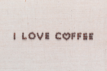I love coffee sign from coffee beans on linen canvas, shot close up.