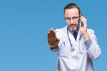 Fototapeta premium Middle age senior hoary doctor man talking on smartphone over isolated background with open hand doing stop sign with serious and confident expression, defense gesture