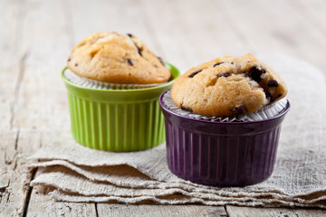 Homemade fresh muffins on ceramic bowls on linen napkin.